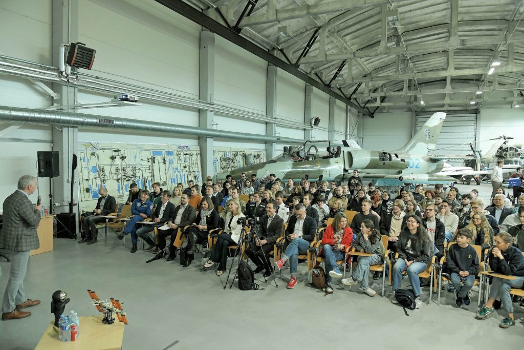 Žmonės angare su lėktuvu