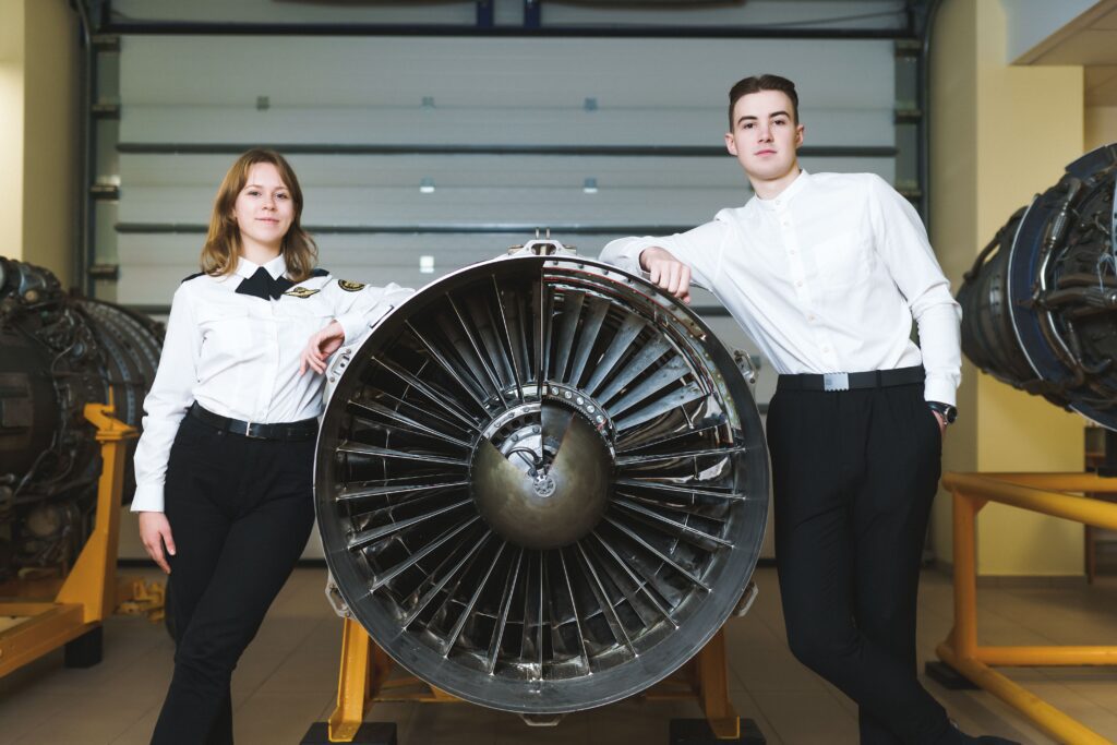 žmonės prie lėktuvo turbinos