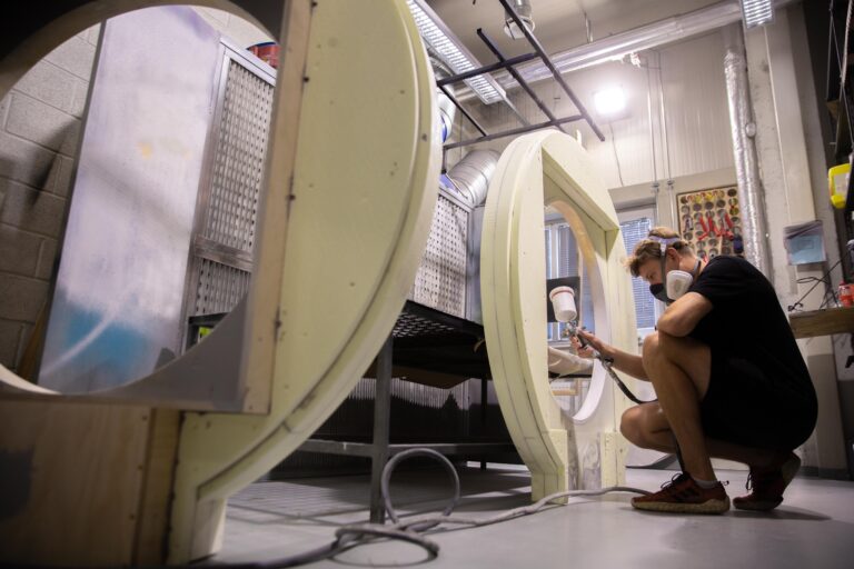 Studentas purškia dažus