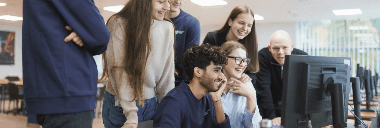 Studentai prie kompiuterio